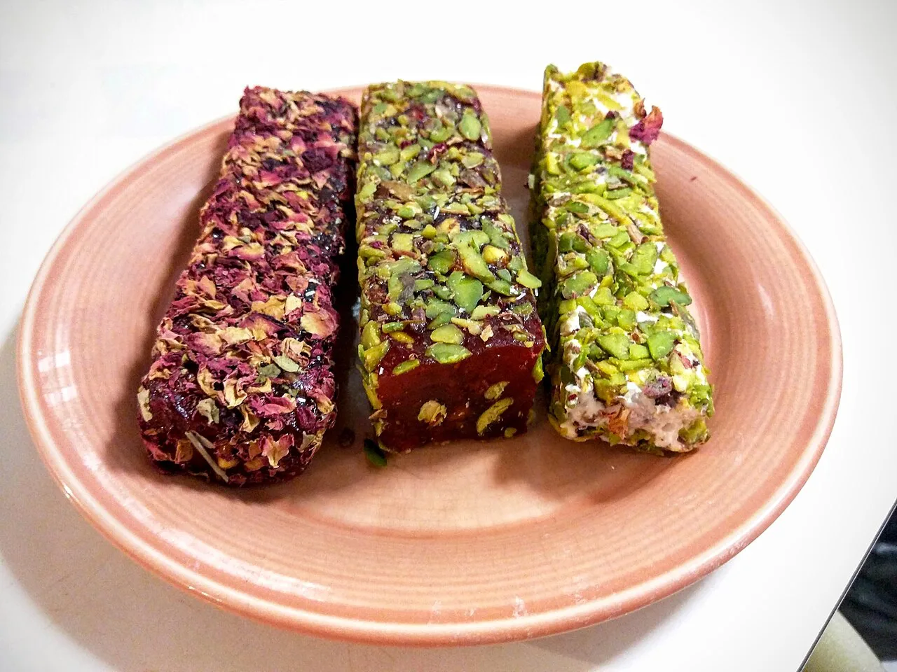 Rolls of Turkish delight coated in nuts and rose petals.